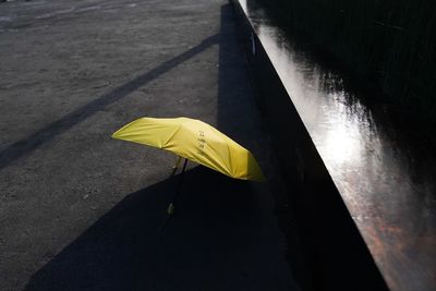 High angle view of yellow umbrella on footpath