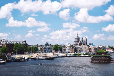 River in city against cloudy sky