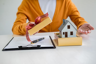 Midsection of man holding paper while sitting on table