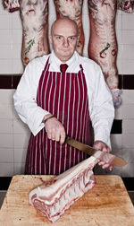 Butcher carving meat in shop