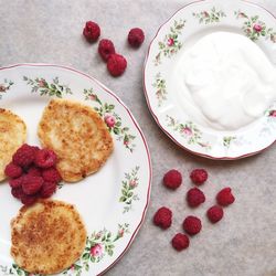 Close-up of fresh pancakes with raspberries and cream in plate