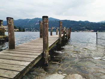 Wooden pier over lake against sky