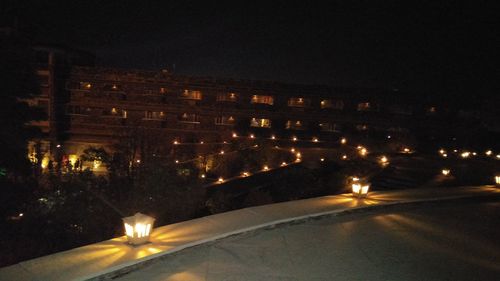 Illuminated buildings against sky at night