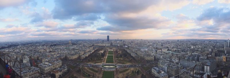 Aerial view of cityscape against cloudy sky