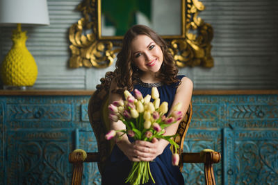 Portrait of young woman holding flower bouquet