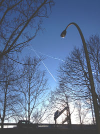 Low angle view of bare trees against sky