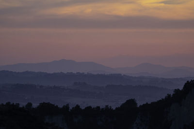 Scenic view of silhouette mountains against sky during sunset