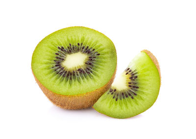 Close-up of kiwi slices over white background