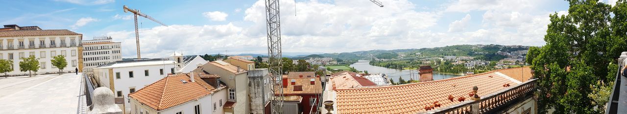 Panoramic view of buildings in town against sky