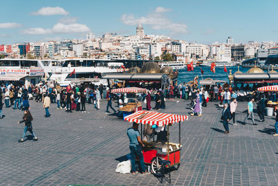People on street against buildings in city