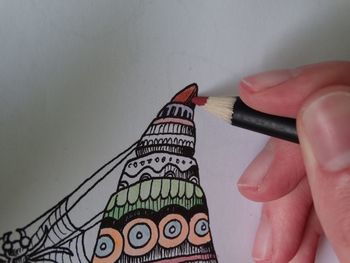 Cropped image of person drawing with colored pencil on paper