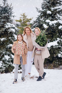 Beautiful family at christmas time in snowy park with gifts