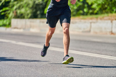 Running man. athletic man jogging in sportswear on city road. healthy lifestyle, fitness hobby