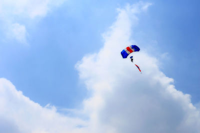 Low angle view of person paragliding against sky