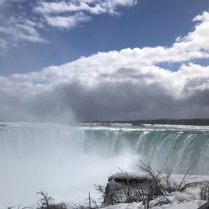 Scenic view of waterfall against sky during winter