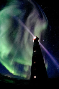 Low angle view of illuminated tower against sky at night