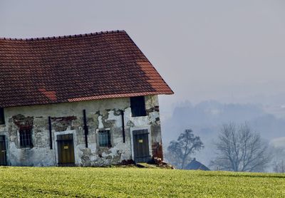 Scenic view of field and old farm houses against sky