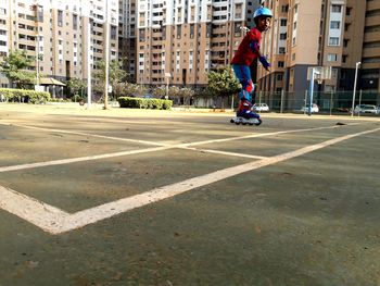 Full length side view of boy inline skating on street in city