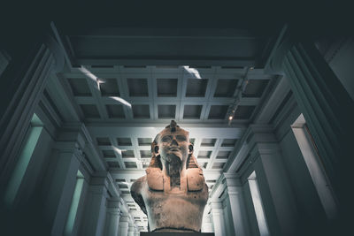 Low angle view of man standing in illuminated room