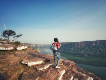 Rear view of man standing on rock