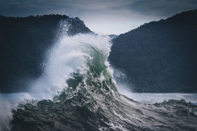 Scenic view of sea waves splashing against sky