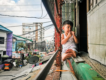 Side view of young woman sitting on street