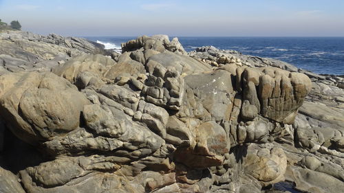 Scenic view of rocky beach against sky