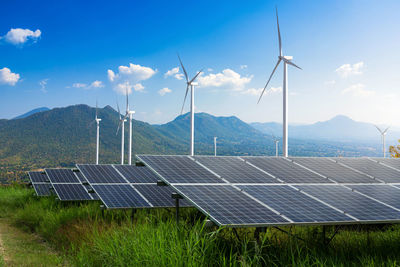 Wind turbines on field against sky