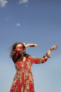 Low angle view of woman standing against sky