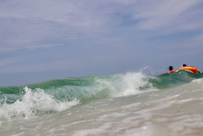 People enjoying in sea against sky