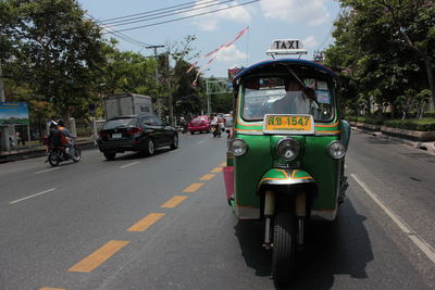 Cars on road in city against sky