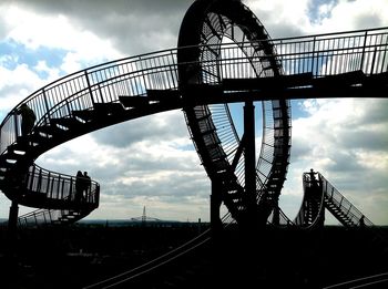 Low angle view of bridge against cloudy sky