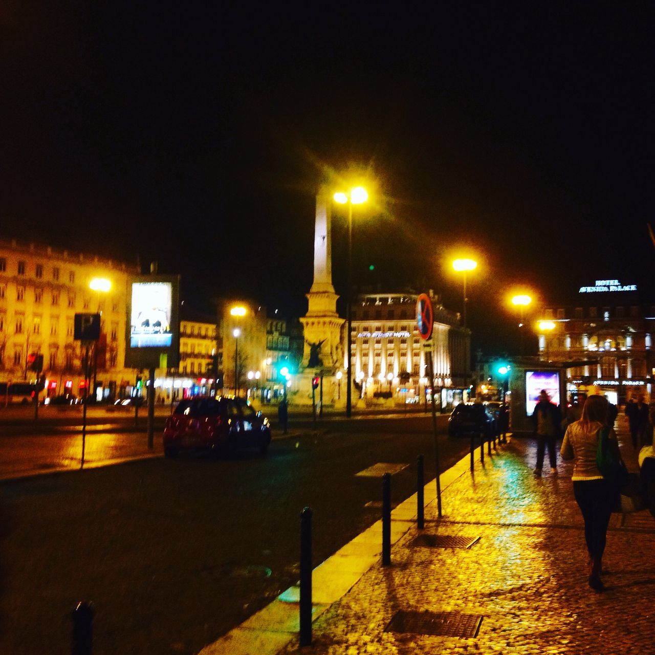 night, illuminated, building exterior, architecture, street light, built structure, street, city, lighting equipment, city life, city street, clear sky, incidental people, transportation, men, walking, outdoors, road, car