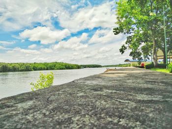 Surface level of road by lake against sky