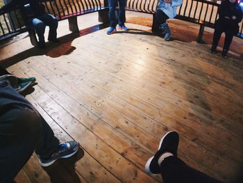 Low section of people sitting on hardwood floor