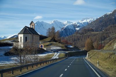 Road amidst snowcapped mountains against sky