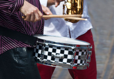 Midsection of men playing music on street