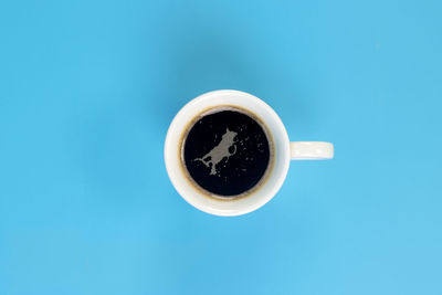 Directly above shot of coffee cup against blue background