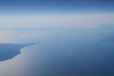 Aerial view of sea and mountains against sky