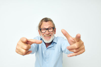 Portrait of senior man gesturing against white background