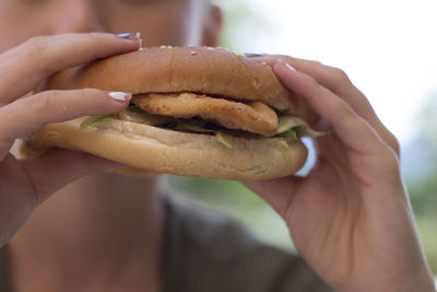 Midsection of woman holding burger