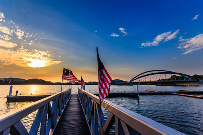 Bridge over river against sky during sunset