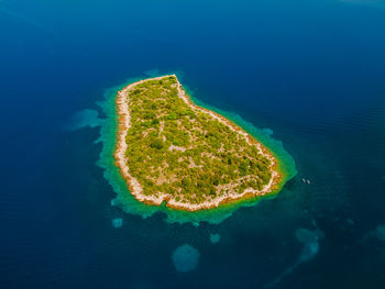 Aerial colourful island with two people on paddle boards in summer time in croatia.