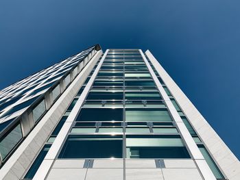 Low angle view of modern building against clear blue sky