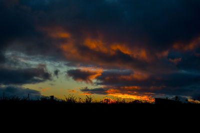 Scenic view of dramatic sky over silhouette landscape