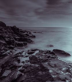 Scenic view of rocks in sea against sky