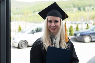 Young woman wearing graduation gown