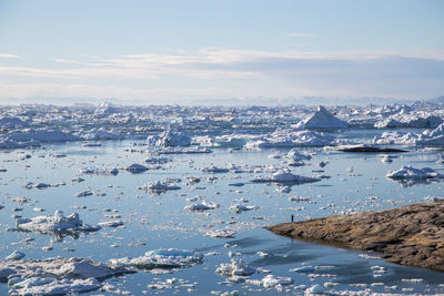 Aerial view of city by sea against sky