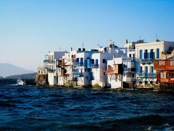 Residential district by sea against clear sky in mykonos