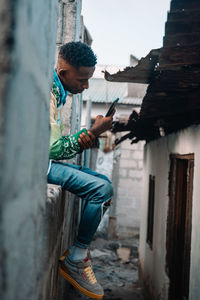 Young man using mobile phone in building